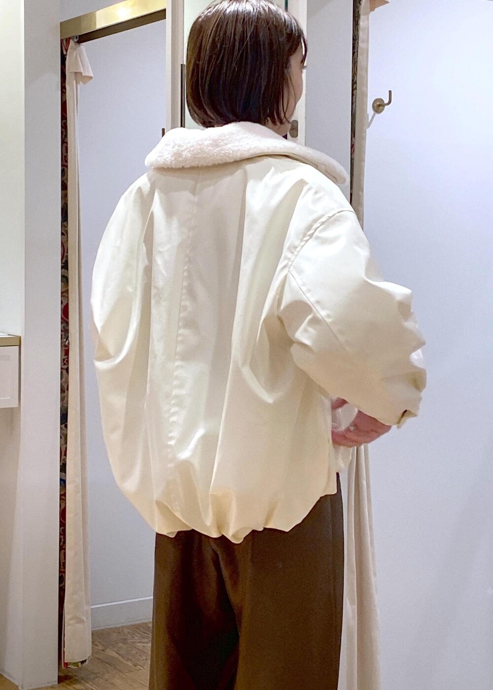 ホワイト系のブルゾン、ホワイト系のニット/セーター、ブラウン系のその他パンツを着用したレディースの冬コーディネートの7枚目の写真