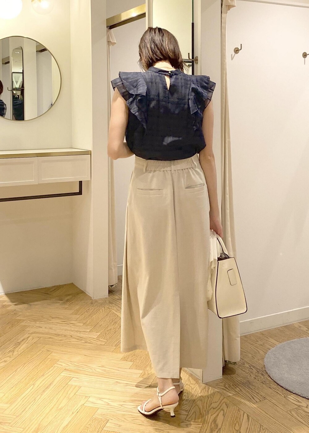 ホワイト系のサンダル、ホワイト系のスカート、ブルー系のシャツ/ブラウスを着用したレディースの春コーディネートの3枚目の写真