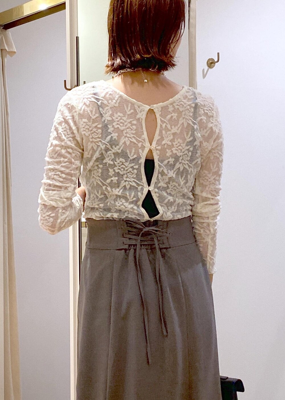 ブラック系のキャミソール、その他のショルダーバッグ、ブラック系のブーツを着用したレディースの秋コーディネートの7枚目の写真