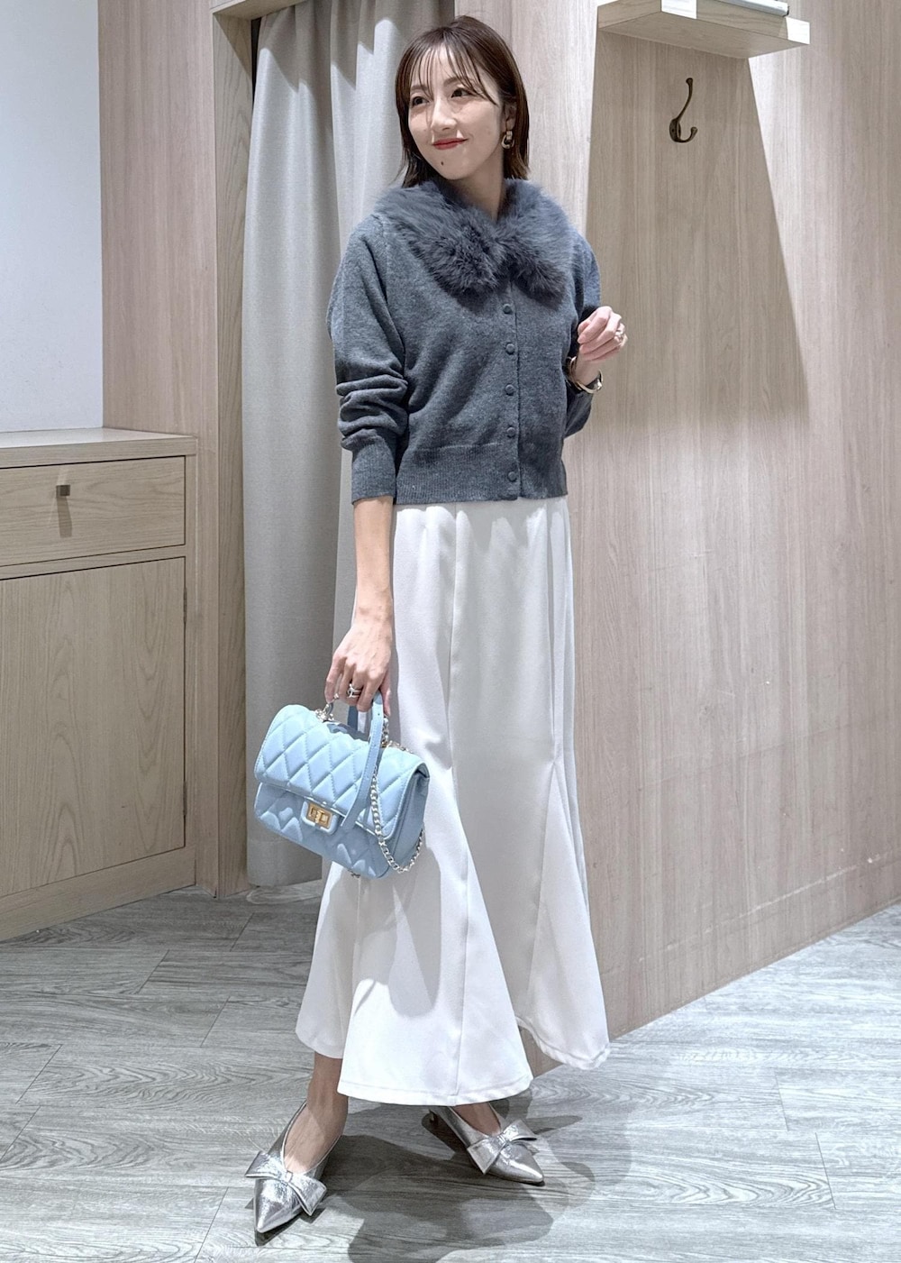 シルバー系のパンプス、ホワイト系のキャミソール、ホワイト系のスカートを着用したレディースの冬コーディネートの3枚目の写真