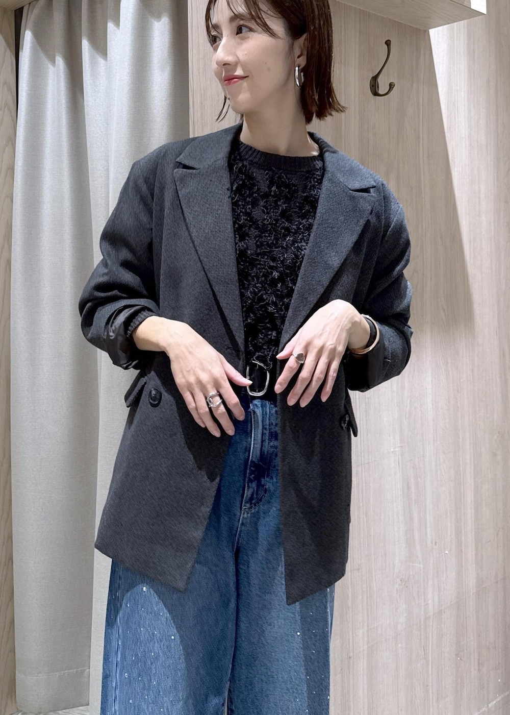 グレー系のニット/セーター、ブルー系のデニムパンツ、グレー系のテーラードジャケットを着用したレディースの冬コーディネートの9枚目の写真