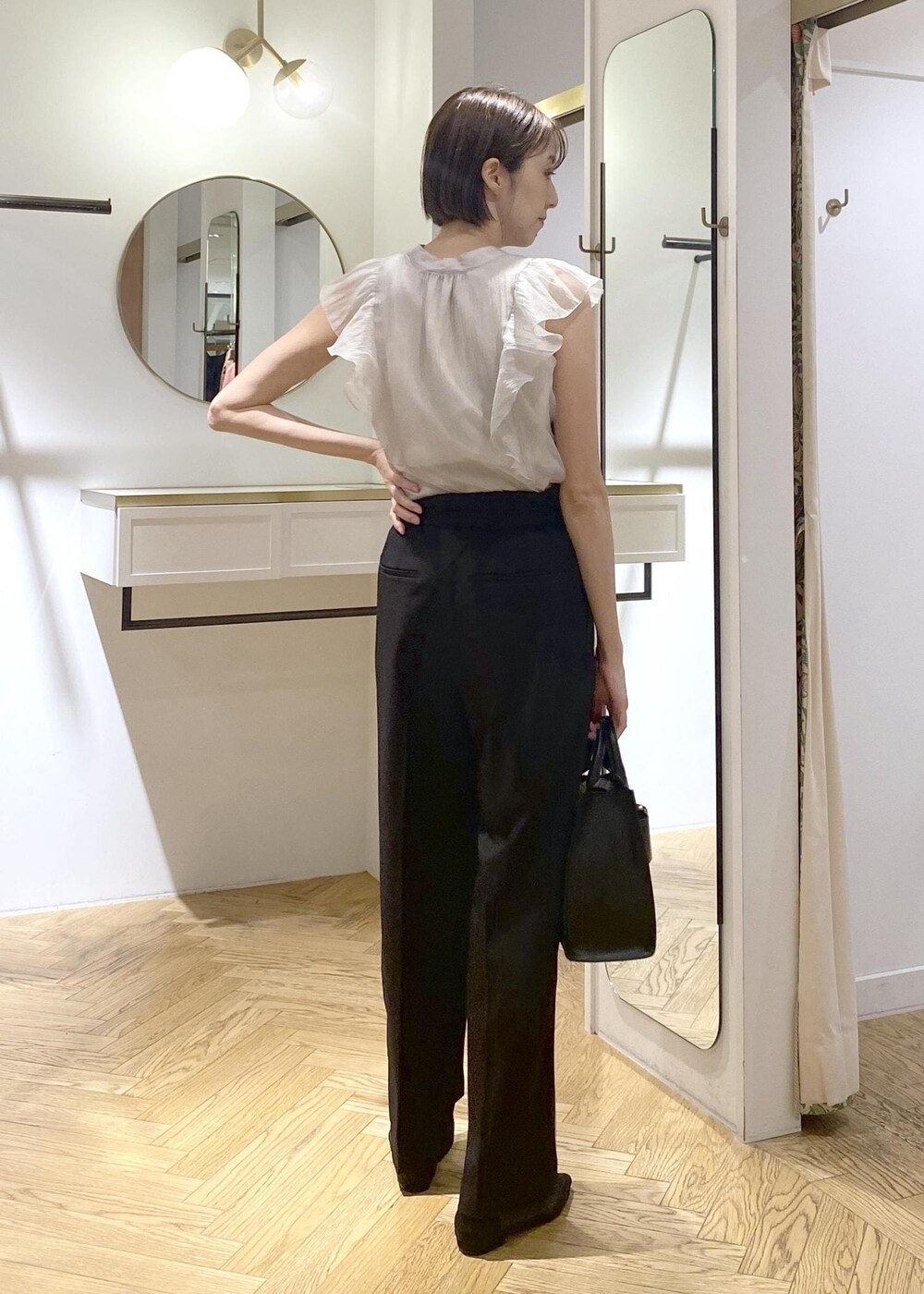 ブラック系のキャミソール、ブラック系のパンプス、ブラック系のハンドバッグを着用したレディースの夏コーディネートの3枚目の写真