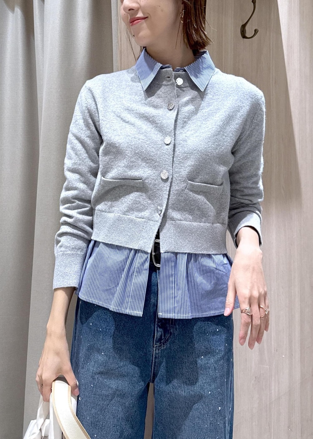 ブルー系のデニムパンツ、グレー系のカーディガン/ボレロ、ホワイト系のトートバッグを着用したレディースの冬コーディネートの6枚目の写真