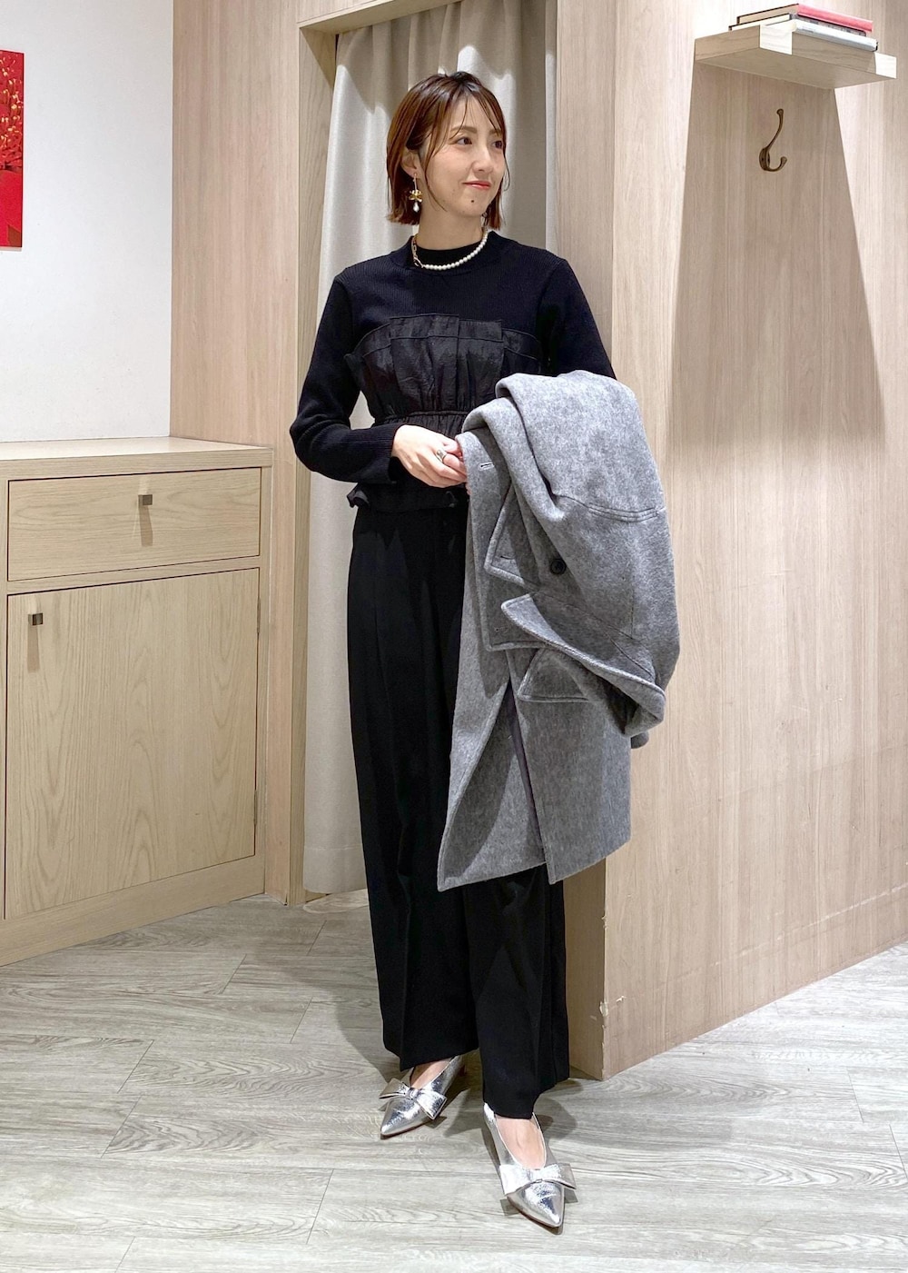 シルバー系のパンプス、ブラック系のスラックス、ブラック系のニット/セーターを着用したレディースの冬コーディネートの7枚目の写真