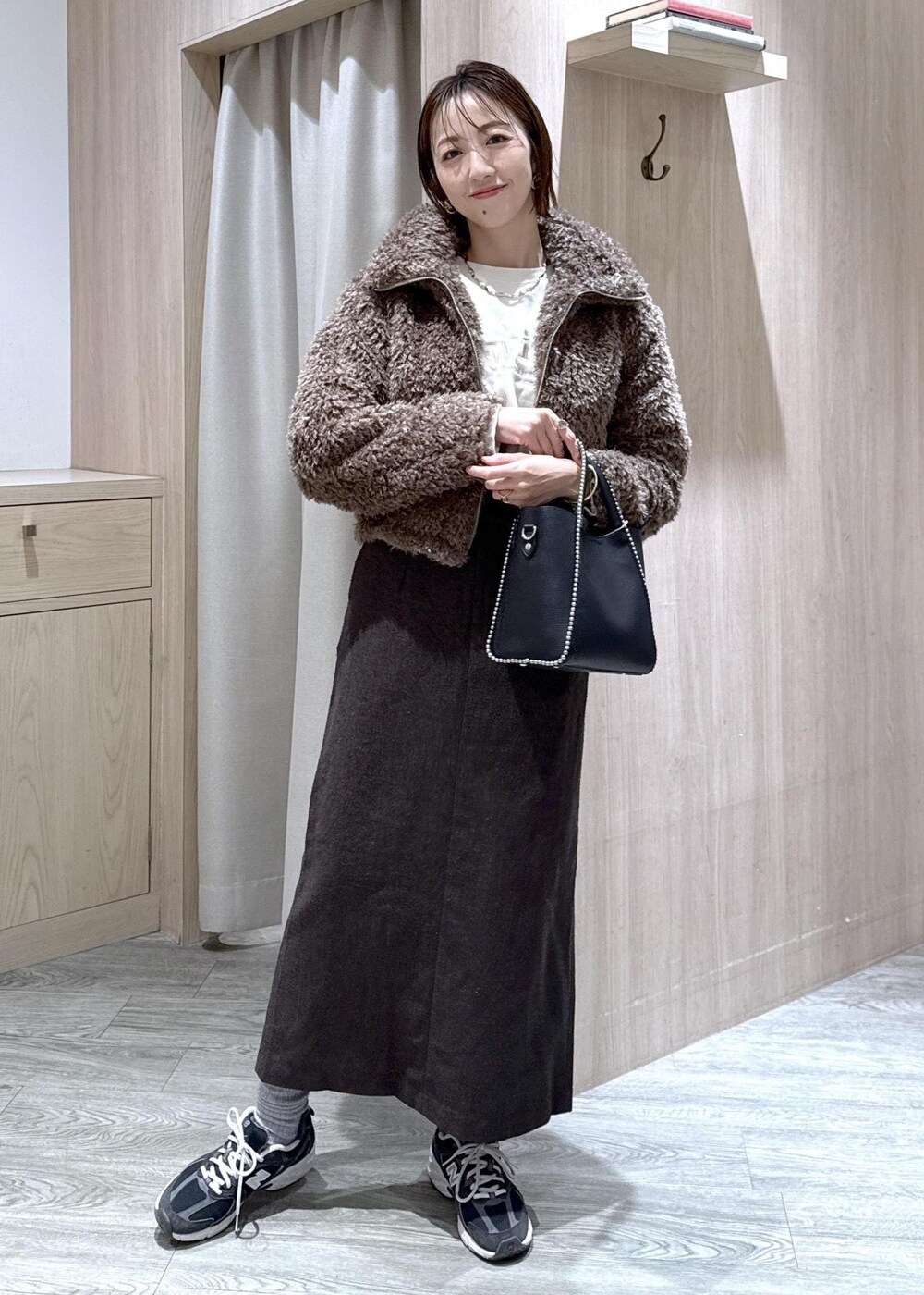 ブラウン系のスカート、ブラウン系のブルゾン、ホワイト系のスウェットを着用したレディースの秋コーディネートの6枚目の写真