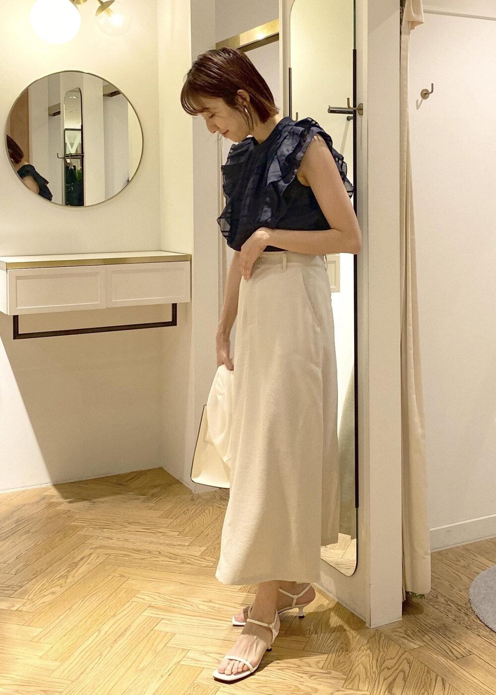 ホワイト系のサンダル、ホワイト系のスカート、ブルー系のシャツ/ブラウスを着用したレディースの春コーディネートの2枚目の写真