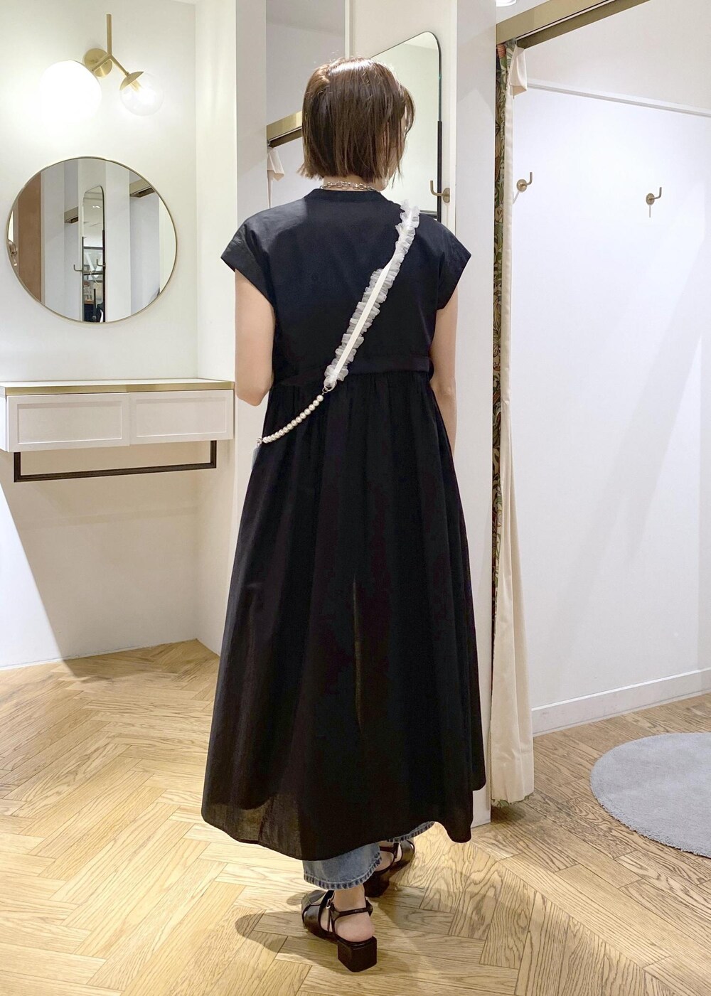 ブラック系のサンダル、ブラック系のワンピース、グリーン系のニット/セーターを着用したレディースの春コーディネートの3枚目の写真