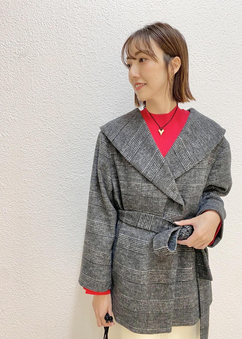 ホワイト系のスカート、ブラック系のその他アウター、ブラック系のハンドバッグを着用したレディースの冬コーディネートの3枚目の写真