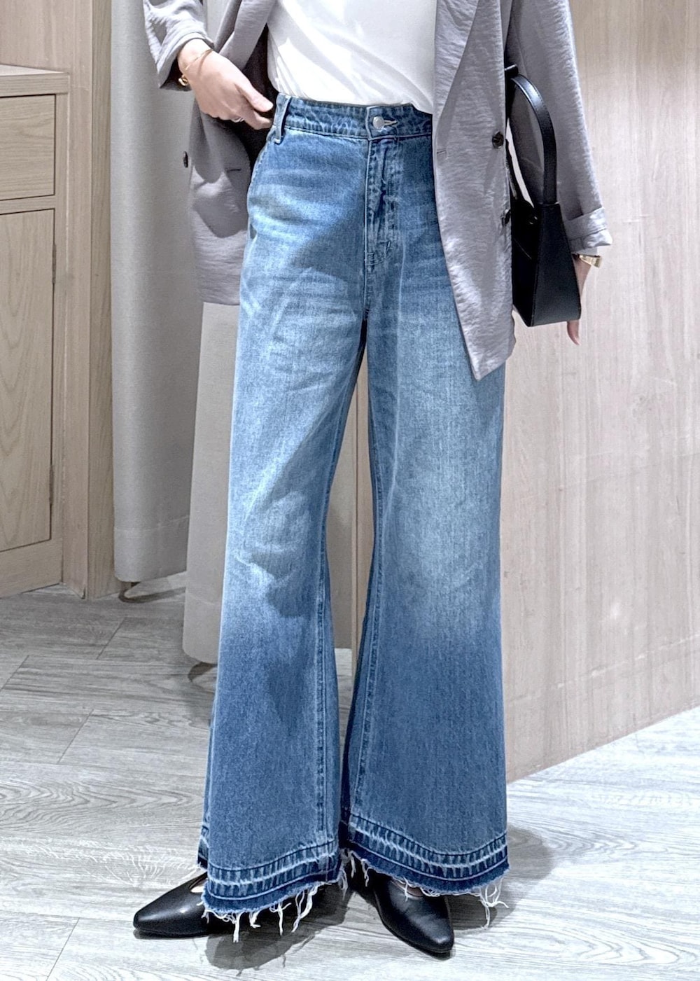 ブラック系のショルダーバッグ、ブラック系のパンプス、ホワイト系のTシャツ/カットソーを着用したレディースの春コーディネートの5枚目の写真