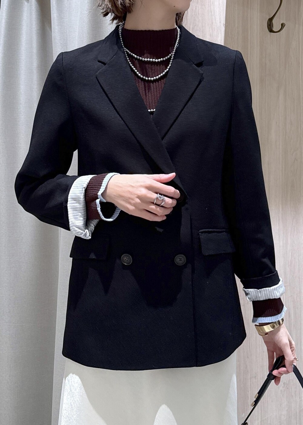 ブラック系のショルダーバッグ、ブラック系のテーラードジャケット、ブラック系のブーツを着用したレディースの冬コーディネートの8枚目の写真