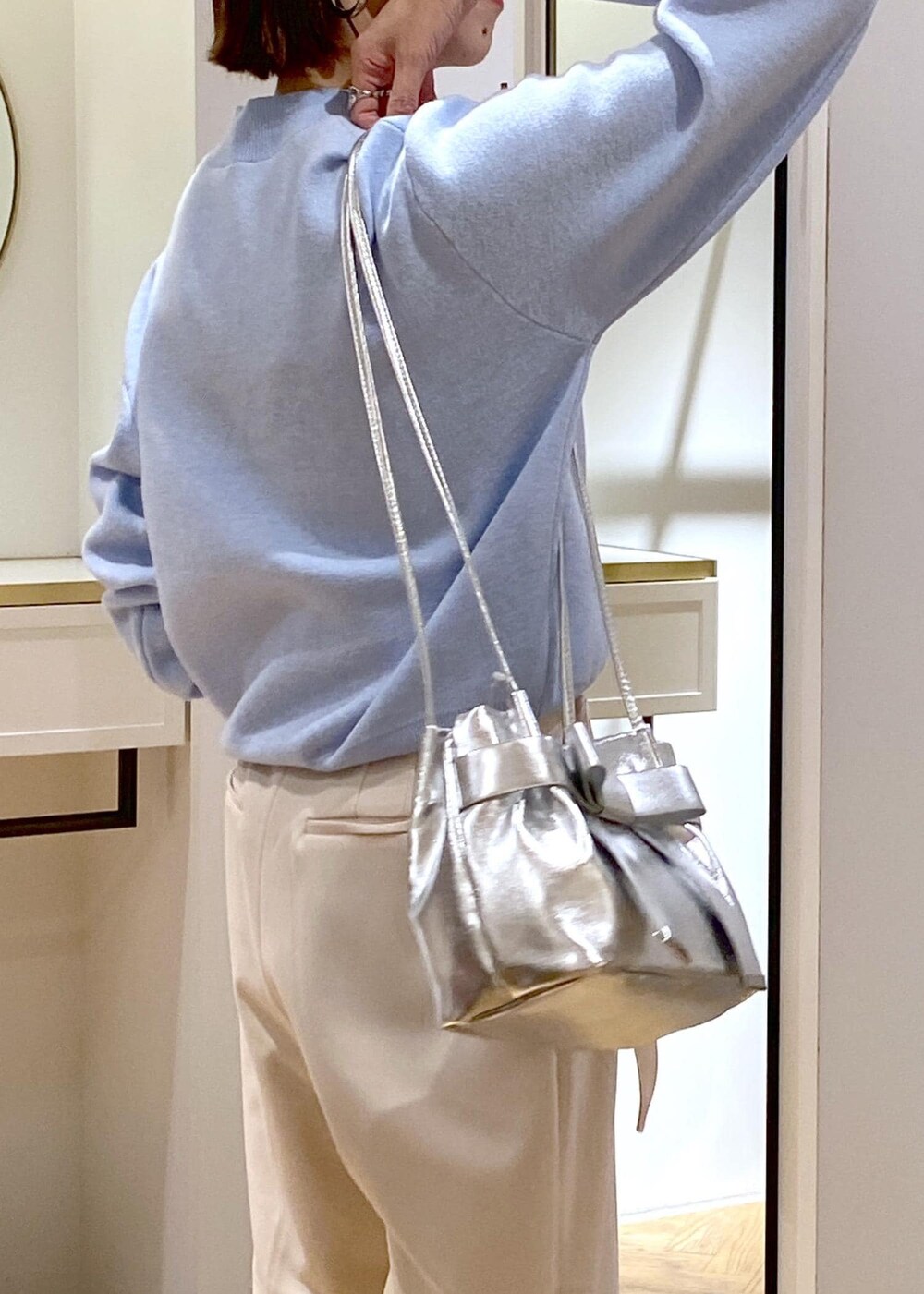 ホワイト系のブーツ、ブルー系のニット/セーター、ベージュ系のその他パンツを着用したレディースの冬コーディネートの6枚目の写真