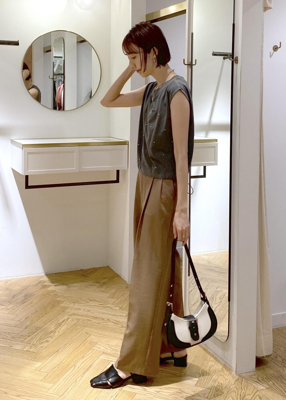 ブラック系のキャミソール、ブラック系のサンダル、ブラック系のショルダーバッグを着用したレディースの夏コーディネートの2枚目の写真