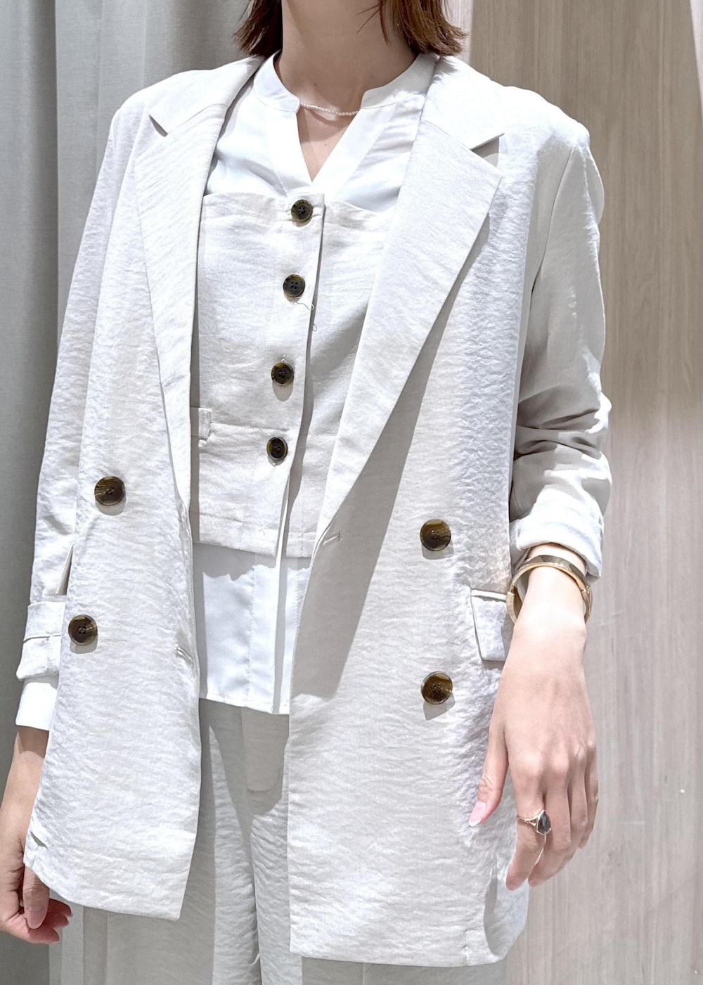 ブラック系のショルダーバッグ、ブラック系のパンプス、ホワイト系のシャツ/ブラウスを着用したレディースの春コーディネートの4枚目の写真