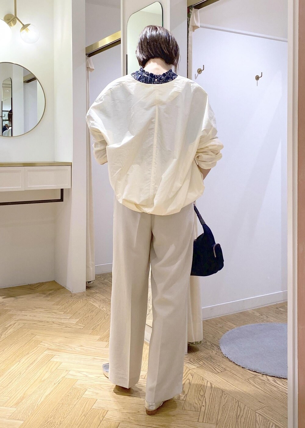 ブルー系のハンドバッグ、シルバー系のパンプス、ブルー系のシャツ/ブラウスを着用したレディースの春コーディネートの2枚目の写真