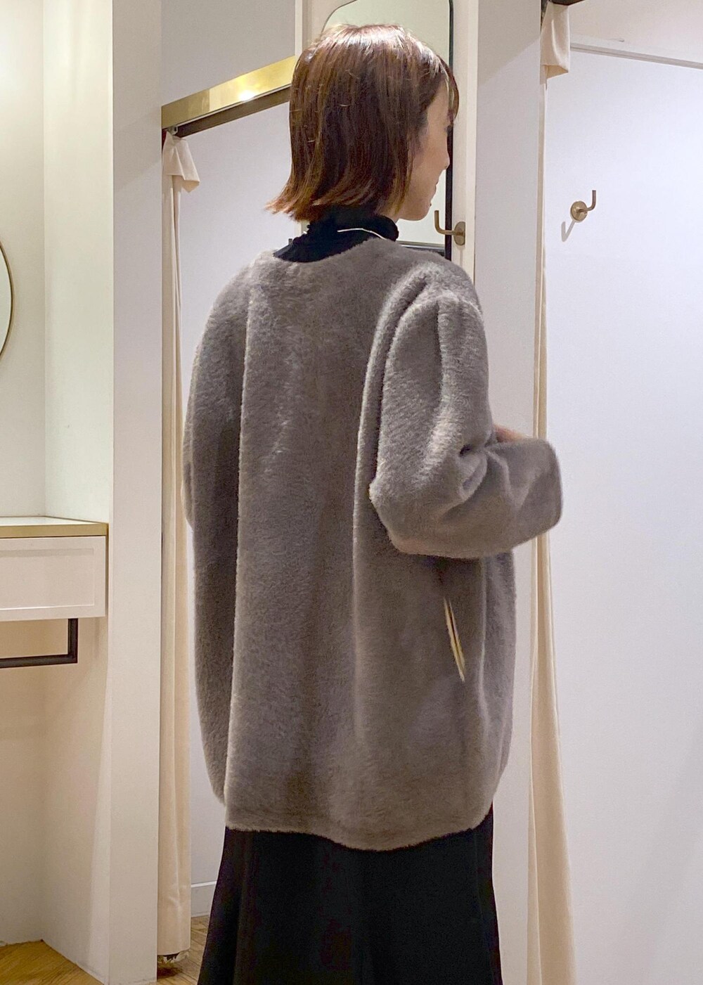 ブラック系のパンプス、ブラック系のスカート、ブラウン系のその他アウターを着用したレディースの秋コーディネートの6枚目の写真