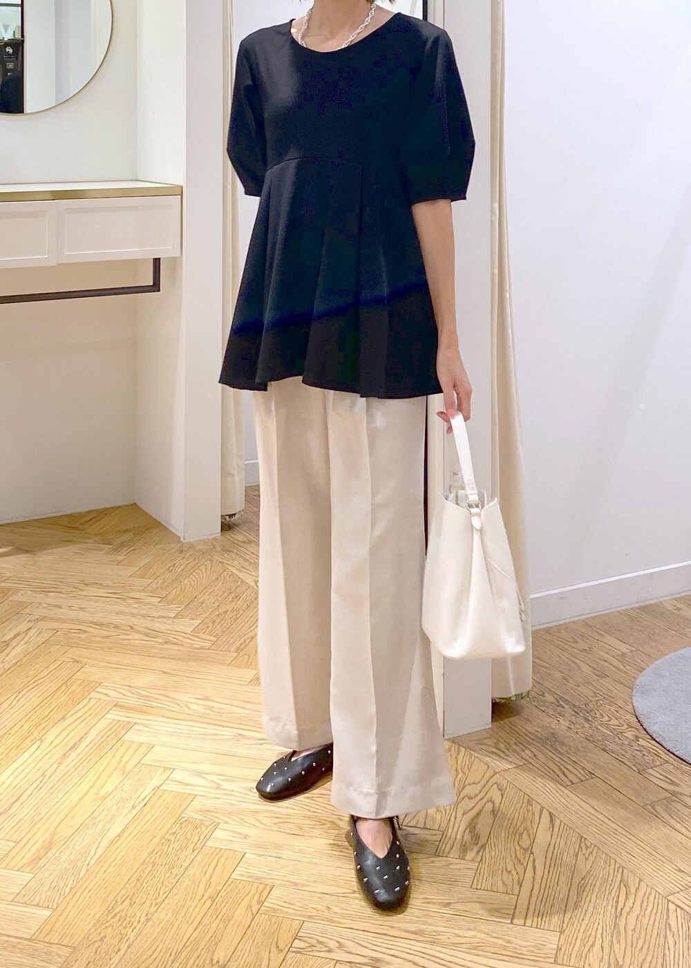 ホワイト系のショルダーバッグ、ホワイト系のスラックス、ブラック系のバレエシューズを着用したレディースの秋コーディネートの4枚目の写真