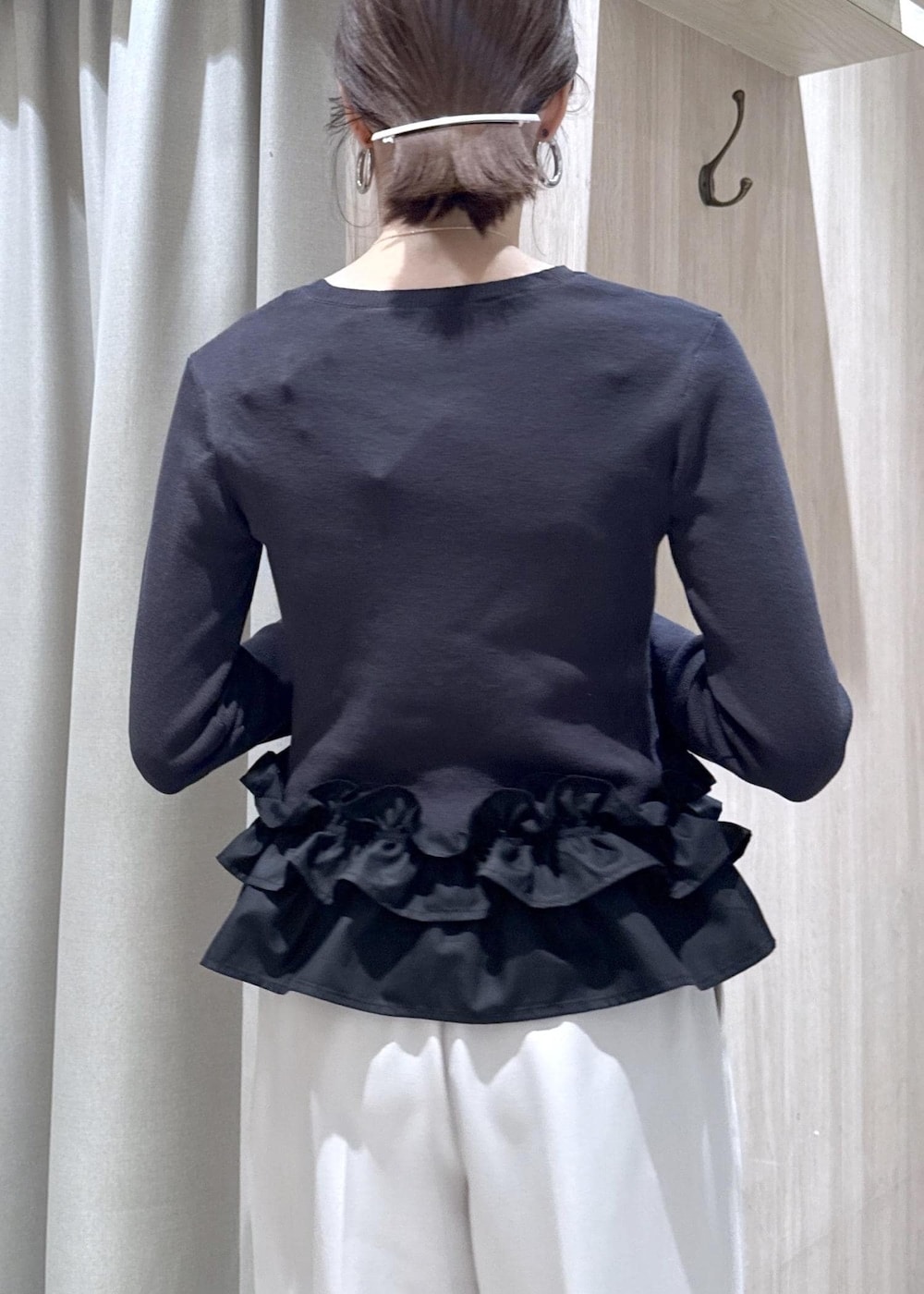 ブラック系のショルダーバッグ、ブラック系のパンプス、グレー系のニット/セーターを着用したレディースの春コーディネートの5枚目の写真