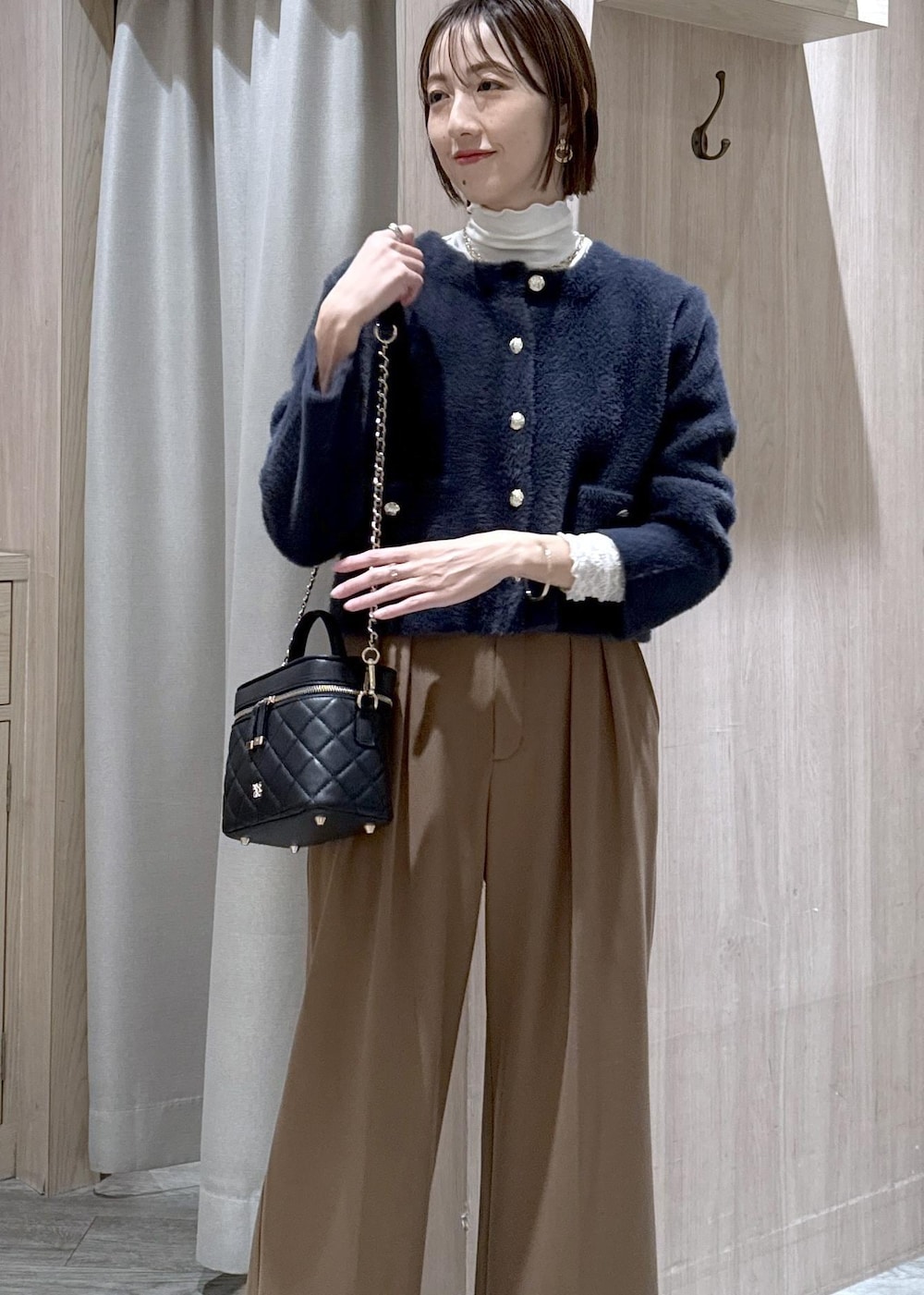 ブルー系のカーディガン/ボレロ、ホワイト系のTシャツ/カットソー、ブラック系のブーツを着用したレディースの冬コーディネートの9枚目の写真