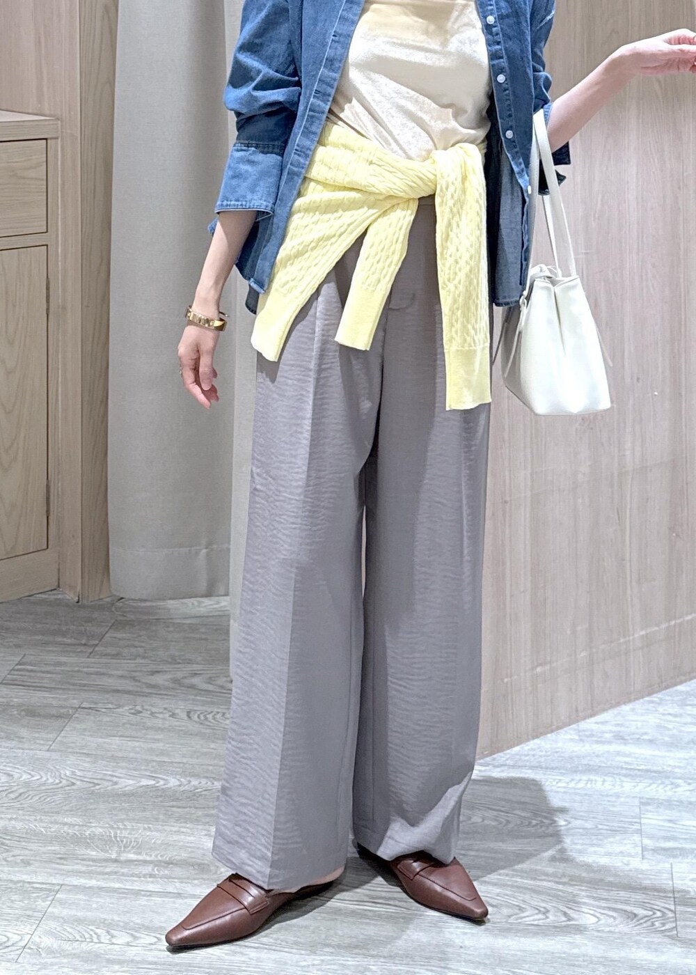 グレー系のその他パンツ、イエロー系のカーディガン/ボレロ、ブルー系のシャツ/ブラウスを着用したレディースの春コーディネートの2枚目の写真