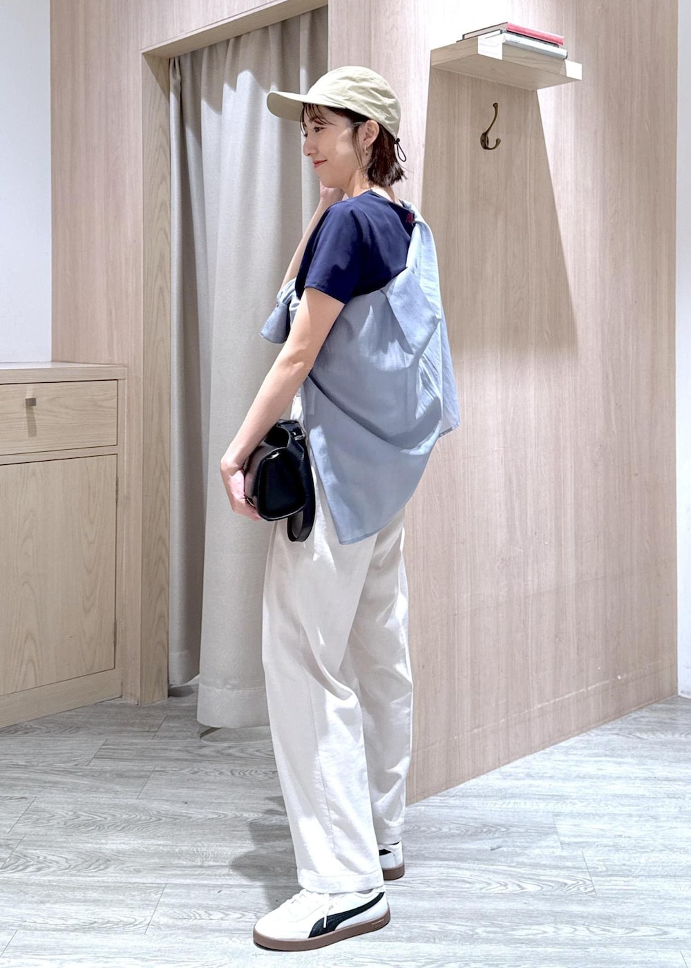 ブラック系のショルダーバッグ、グレー系のシャツ/ブラウス、ホワイト系のスラックスを着用したレディースの春コーディネートの6枚目の写真