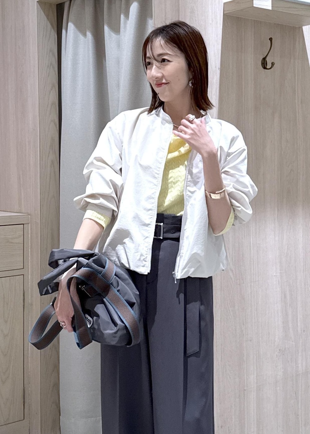 ホワイト系のパンプス、グレー系のトートバッグ、ホワイト系のブルゾンを着用したレディースの春コーディネートの4枚目の写真