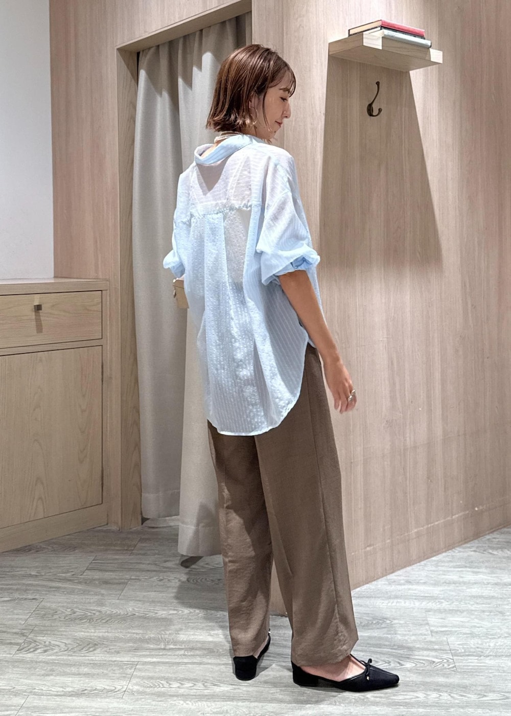 グリーン系のスラックス、ブラック系のパンプス、ベージュ系のボストンバッグを着用したレディースの秋コーディネートの5枚目の写真