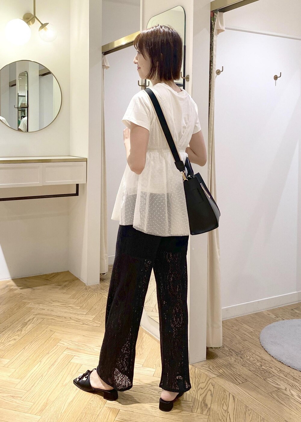 ブラック系のサンダル、ブラック系のハンドバッグ、ホワイト系のTシャツ/カットソーを着用したレディースの春コーディネートの3枚目の写真