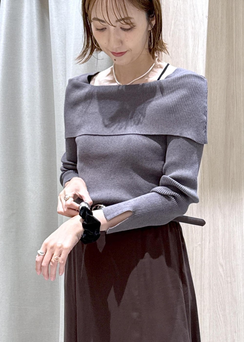 ホワイト系のパンプス、ブラウン系のスカート、グレー系のニット/セーターを着用したレディースの秋コーディネートの8枚目の写真
