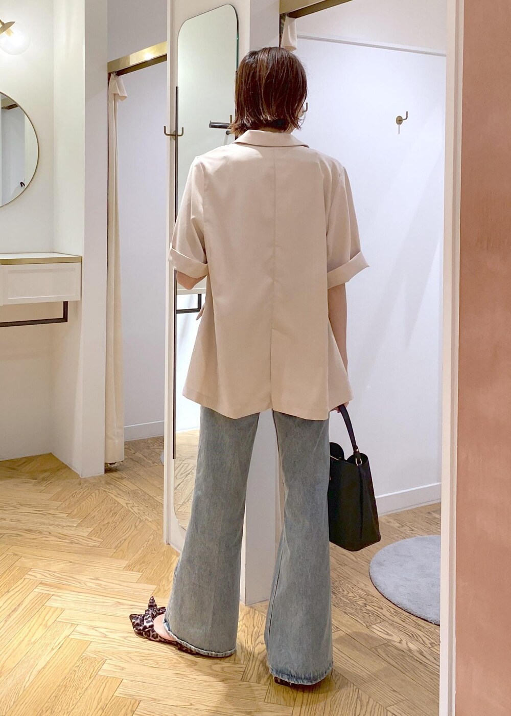 ブラック系のキャミソール、ホワイト系のテーラードジャケット、その他のサンダルを着用したレディースの夏コーディネートの2枚目の写真