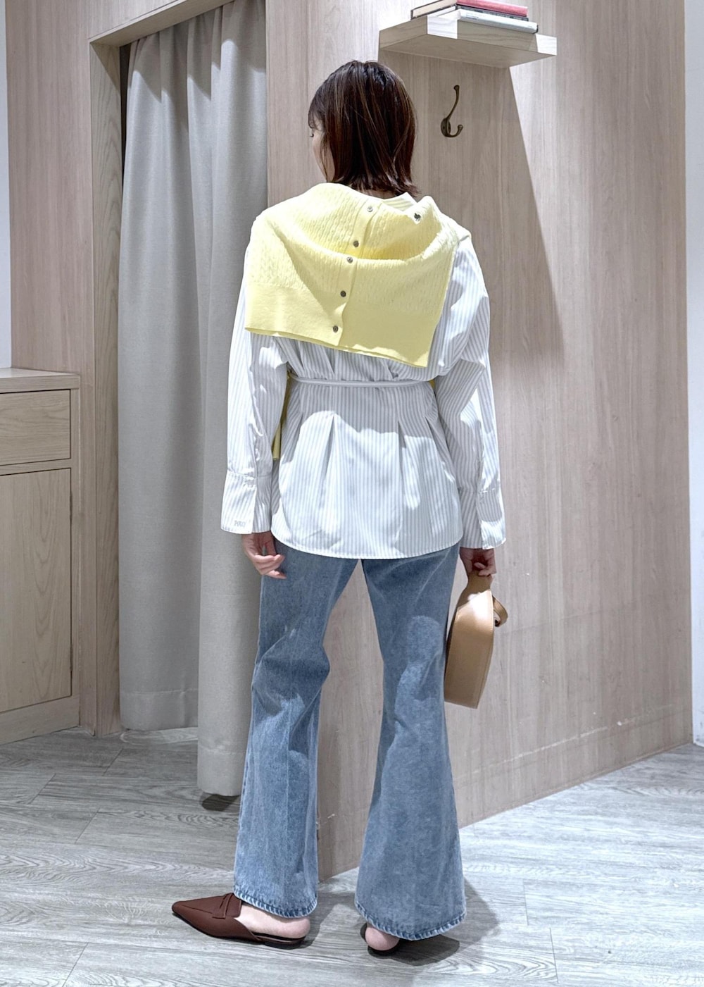 ブルー系のデニムパンツ、イエロー系のショルダーバッグ、ベージュ系のシャツ/ブラウスを着用したレディースの春コーディネートの5枚目の写真