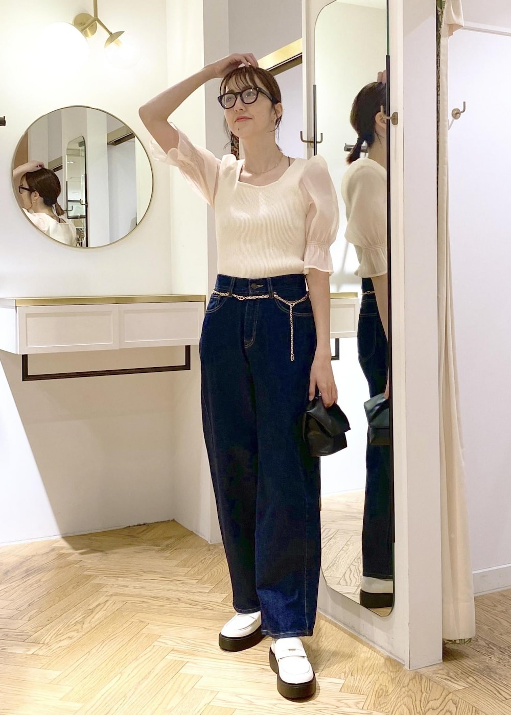 ホワイト系のローファー、ブラック系のショルダーバッグ、ブルー系のデニムパンツを着用したレディースの春コーディネートの4枚目の写真