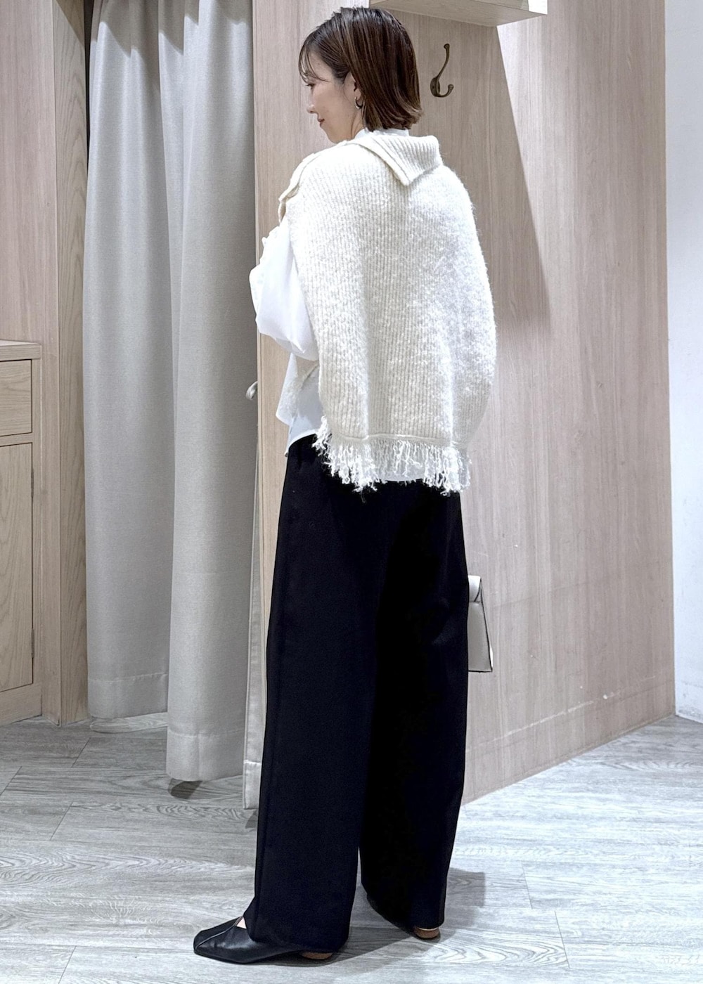 ブラック系のスラックス、ホワイト系のベスト、ホワイト系のシャツ/ブラウスを着用したレディースの秋コーディネートの2枚目の写真