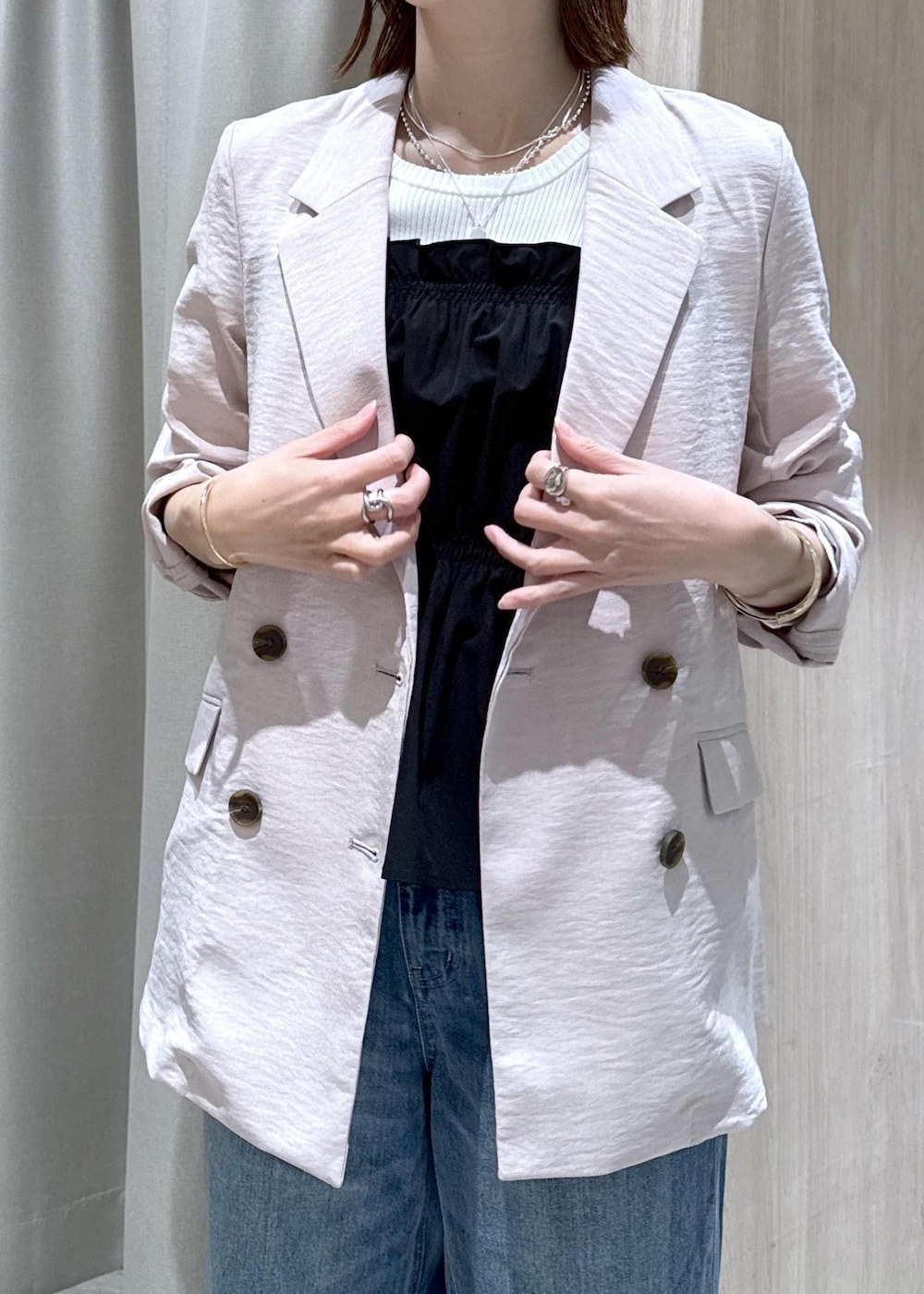 ホワイト系のトートバッグ、ブルー系のデニムパンツ、ブラック系のニット/セーターを着用したレディースの春コーディネートの5枚目の写真