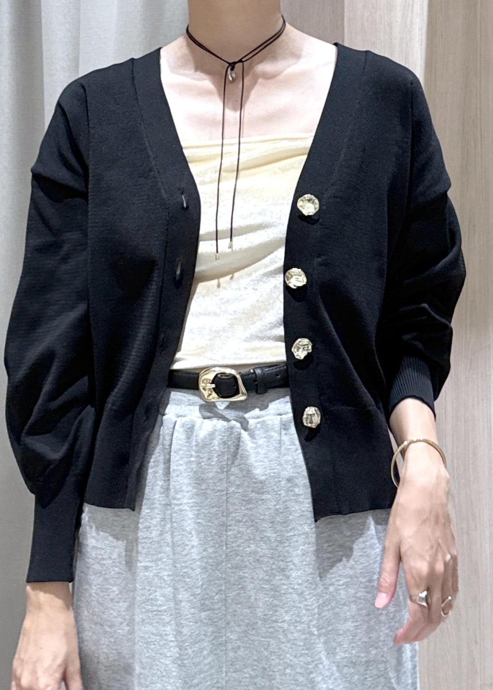 グレー系のスカート、ホワイト系のキャミソール、ブラック系のカーディガン/ボレロを着用したレディースの秋コーディネートの9枚目の写真