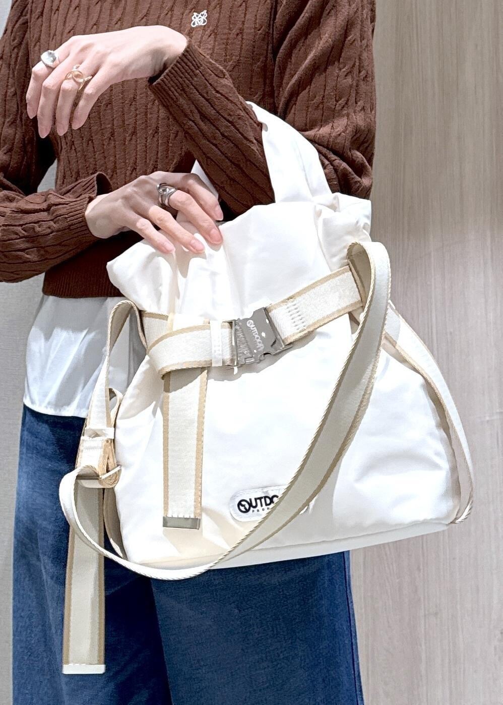 グレー系のその他アウター、ブラウン系のニット/セーター、ブルー系のデニムパンツを着用したレディースの冬コーディネートの7枚目の写真