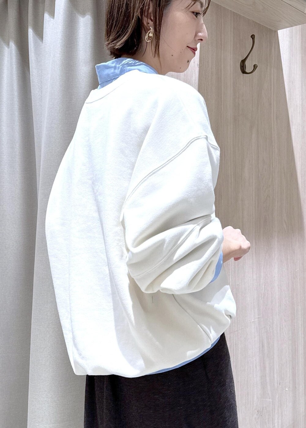 グレー系のショルダーバッグ、ブラック系のブーツ、ブラウン系のスカートを着用したレディースの秋コーディネートの7枚目の写真