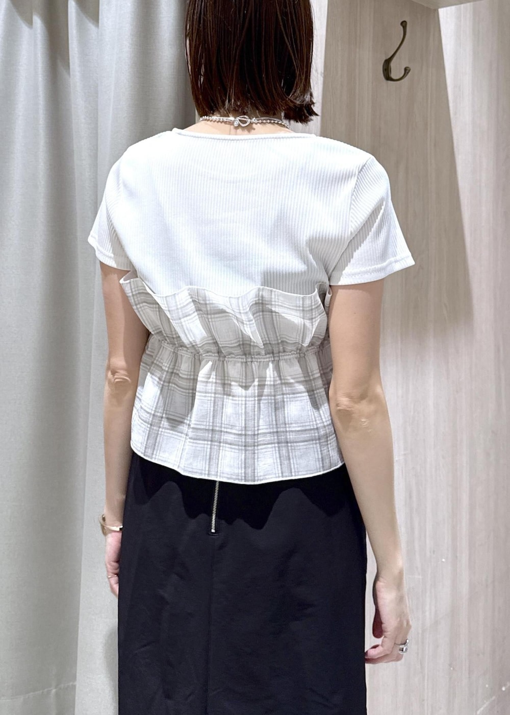 ブラック系のパンプス、ブラック系のスカート、ホワイト系のTシャツ/カットソーを着用したレディースの春コーディネートの6枚目の写真