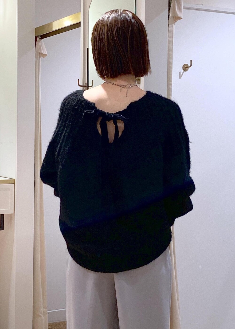 ブルー系のスラックス、ブラック系のパンプス、ブラック系のショルダーバッグを着用したレディースの冬コーディネートの8枚目の写真