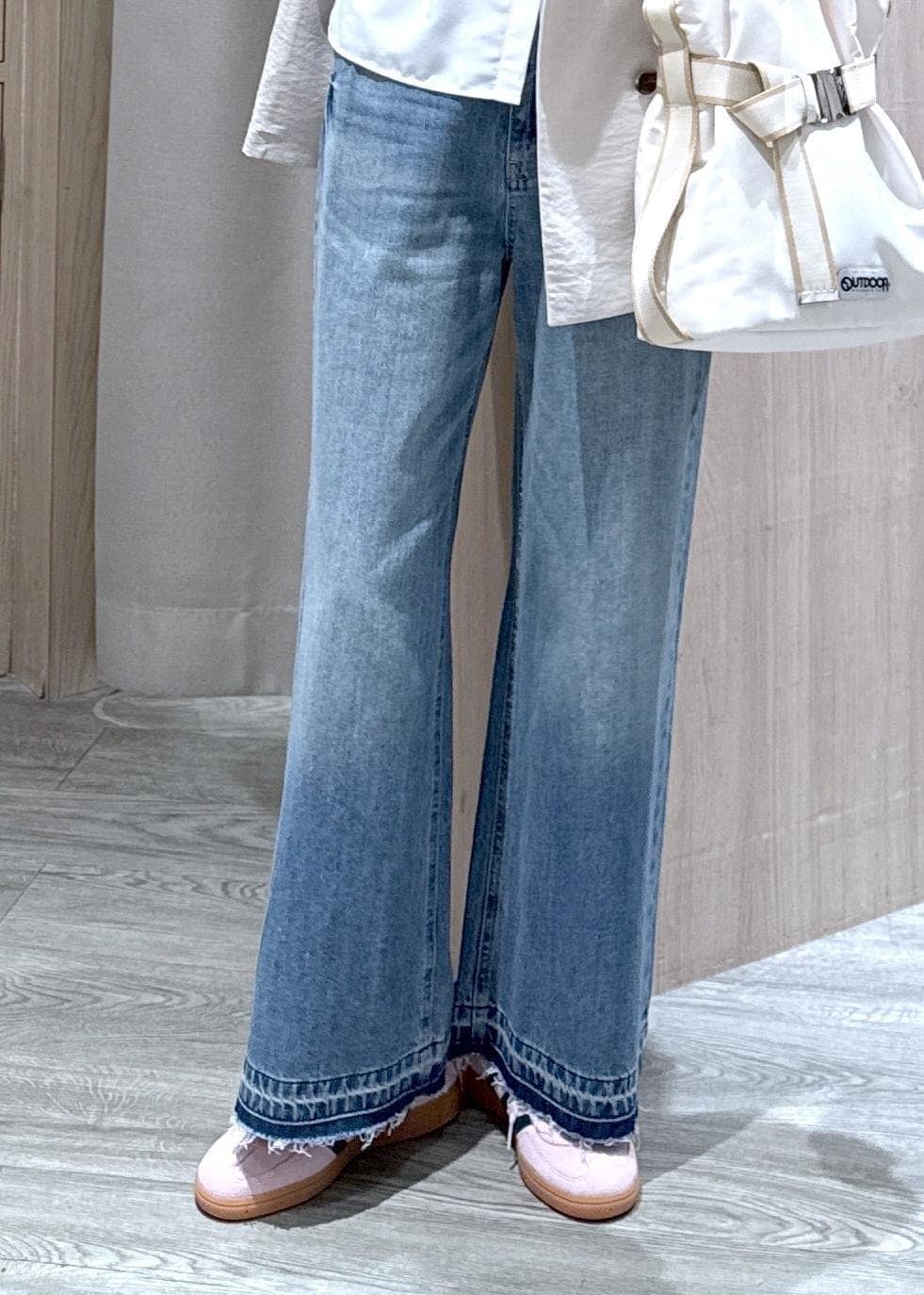 ホワイト系のトートバッグ、ブルー系のデニムパンツ、ホワイト系のシャツ/ブラウスを着用したレディースの春コーディネートの4枚目の写真