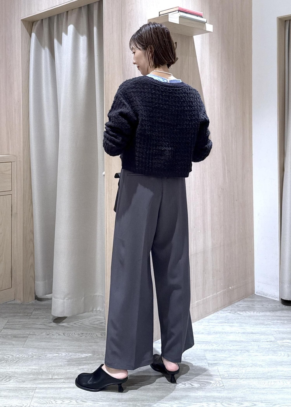 ブラック系のハンドバッグ、ブルー系のカーディガン/ボレロ、グレー系のその他パンツを着用したレディースの秋コーディネートの3枚目の写真