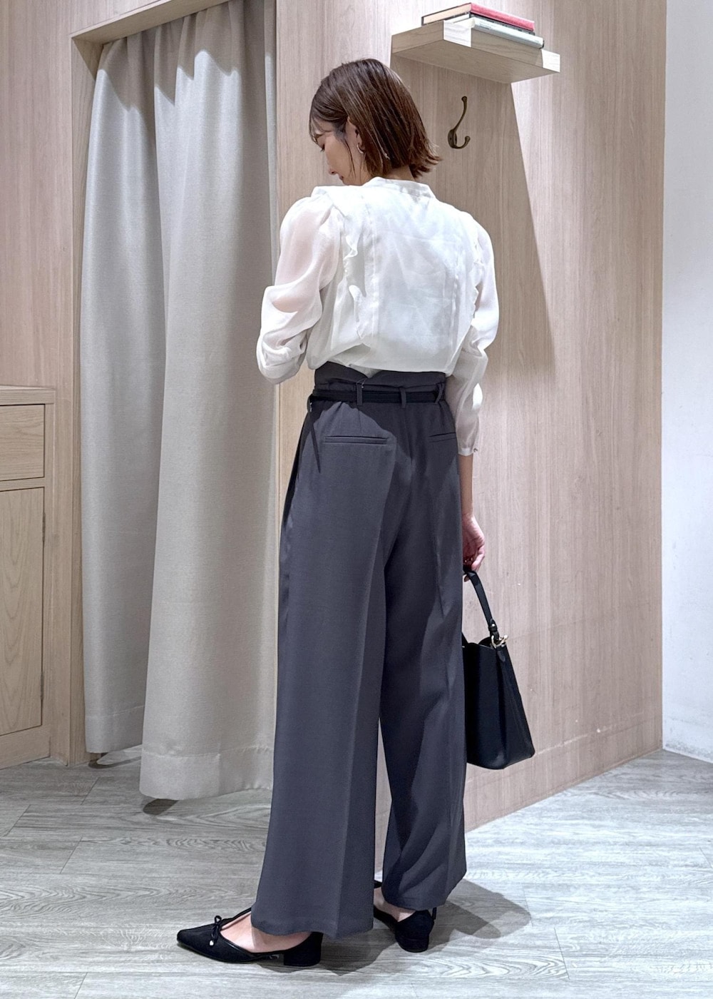 ブラック系のショルダーバッグ、グレー系のスラックス、ホワイト系のシャツ/ブラウスを着用したレディースの秋コーディネートの3枚目の写真