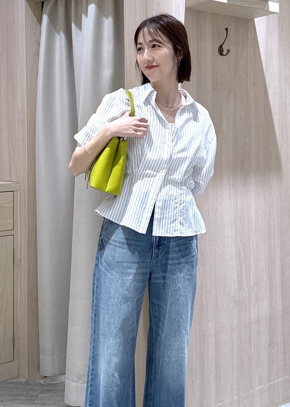 ブルー系のデニムパンツ、グリーン系のトートバッグ、ホワイト系のシャツ/ブラウスを着用したレディースの春コーディネートの6枚目の写真