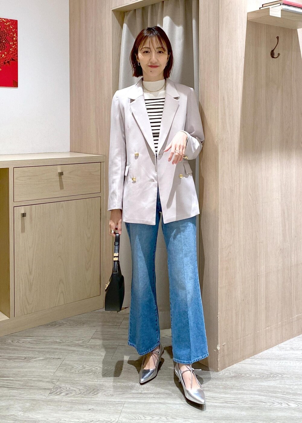 ブラック系のハンドバッグ、ホワイト系のニット/セーター、ベージュ系のテーラードジャケットを着用したレディースの冬コーディネートの2枚目の写真