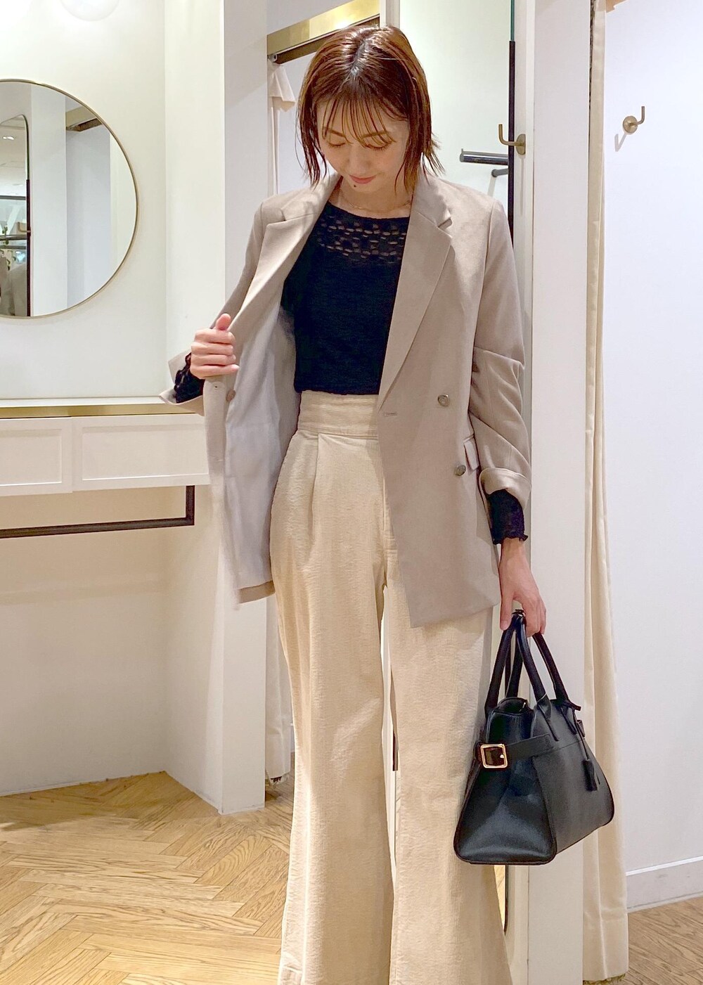 ブラック系のトートバッグ、ブラウン系のブーツ、ブラック系のTシャツ/カットソーを着用したレディースの秋コーディネートの4枚目の写真