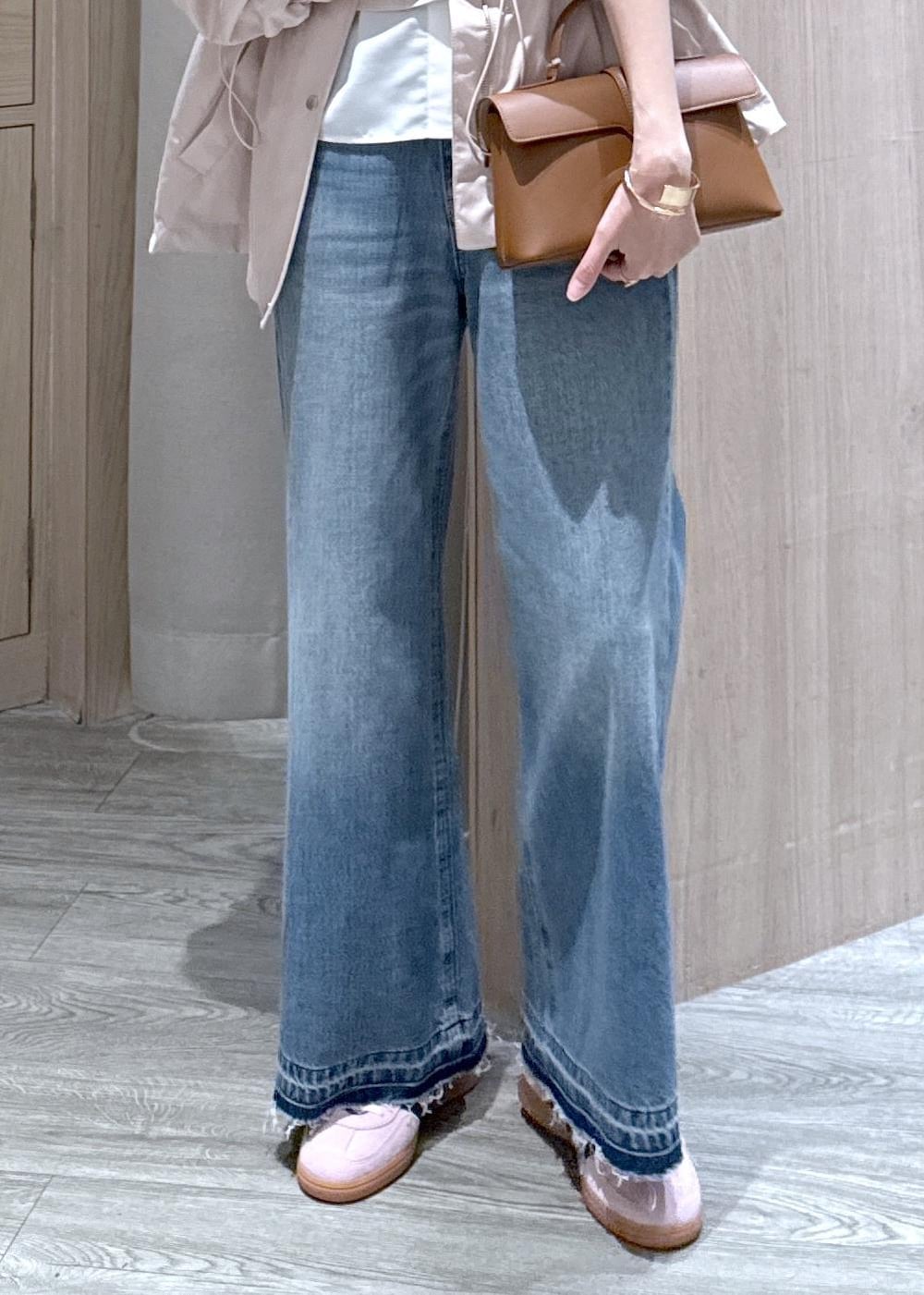 イエロー系のショルダーバッグ、ピンク系のナイロンジャケット、ブルー系のデニムパンツを着用したレディースの春コーディネートの6枚目の写真