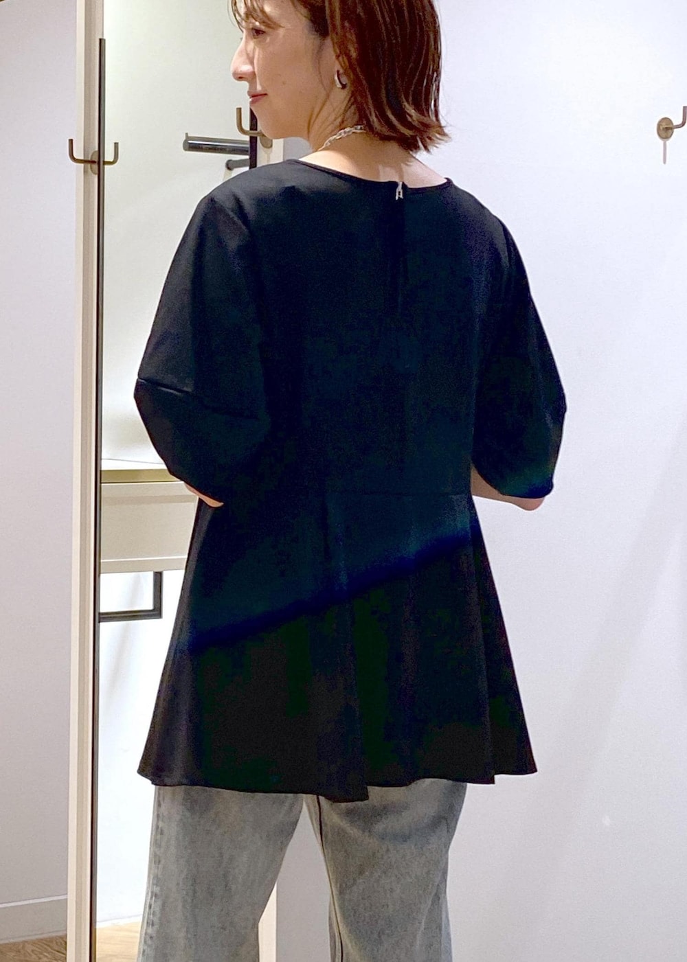 ブラック系のブーツ、ブラック系のTシャツ/カットソー、ブルー系のデニムパンツを着用したレディースの秋コーディネートの10枚目の写真