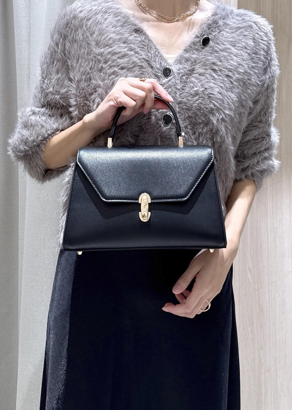 グレー系のカーディガン/ボレロ、グレー系のその他アウター、ブラック系のブーツを着用したレディースの秋コーディネートの3枚目の写真