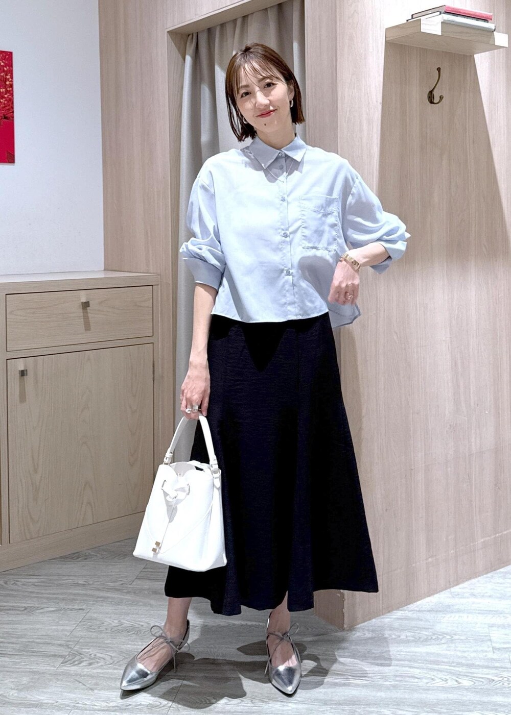 ホワイト系のショルダーバッグ、シルバー系のパンプス、ブラック系のスカートを着用したレディースの春コーディネートの9枚目の写真