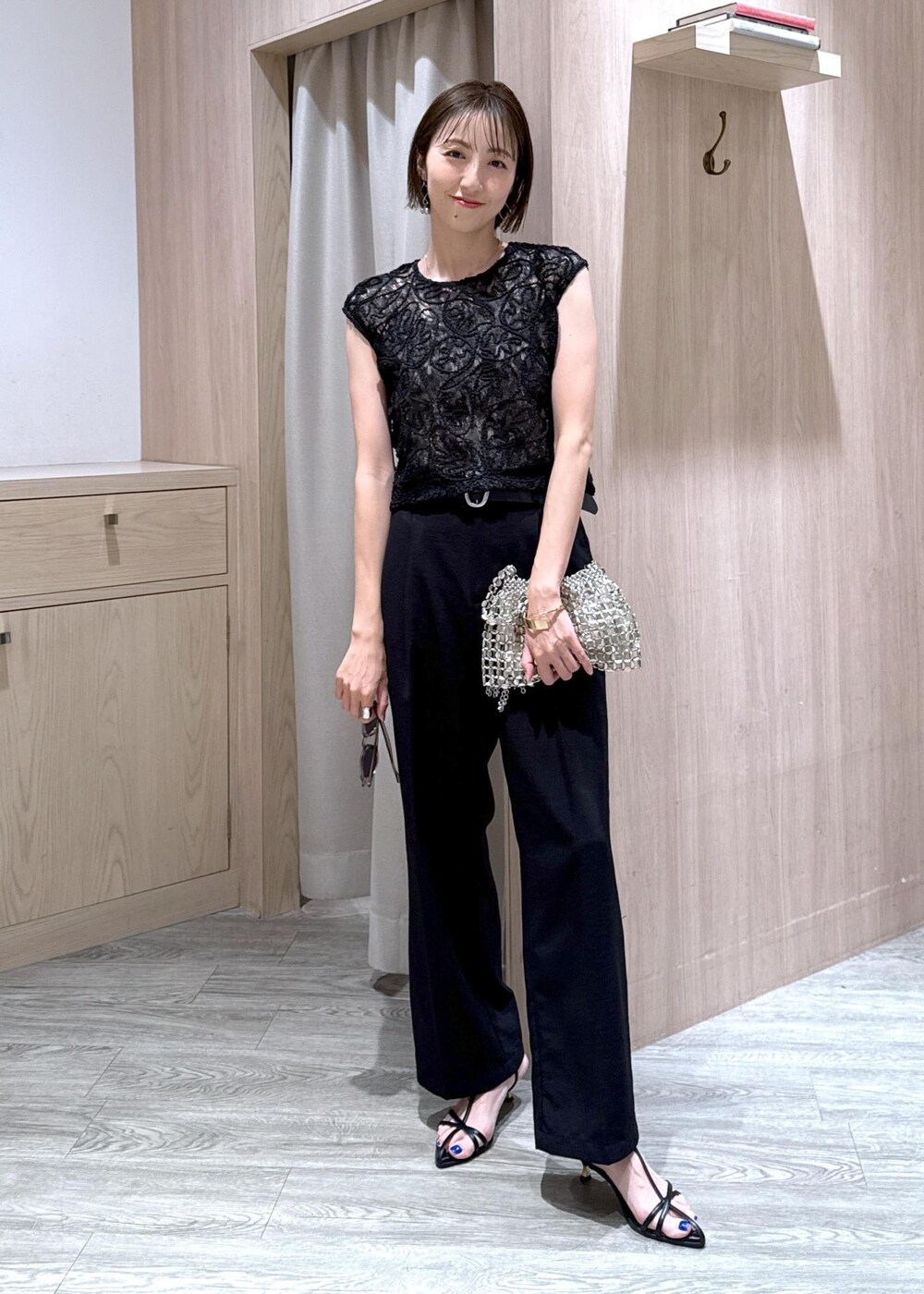 ベージュ系のキャミソール、ブラック系のサンダル、ブラック系のスラックスを着用したレディースの夏コーディネートの2枚目の写真