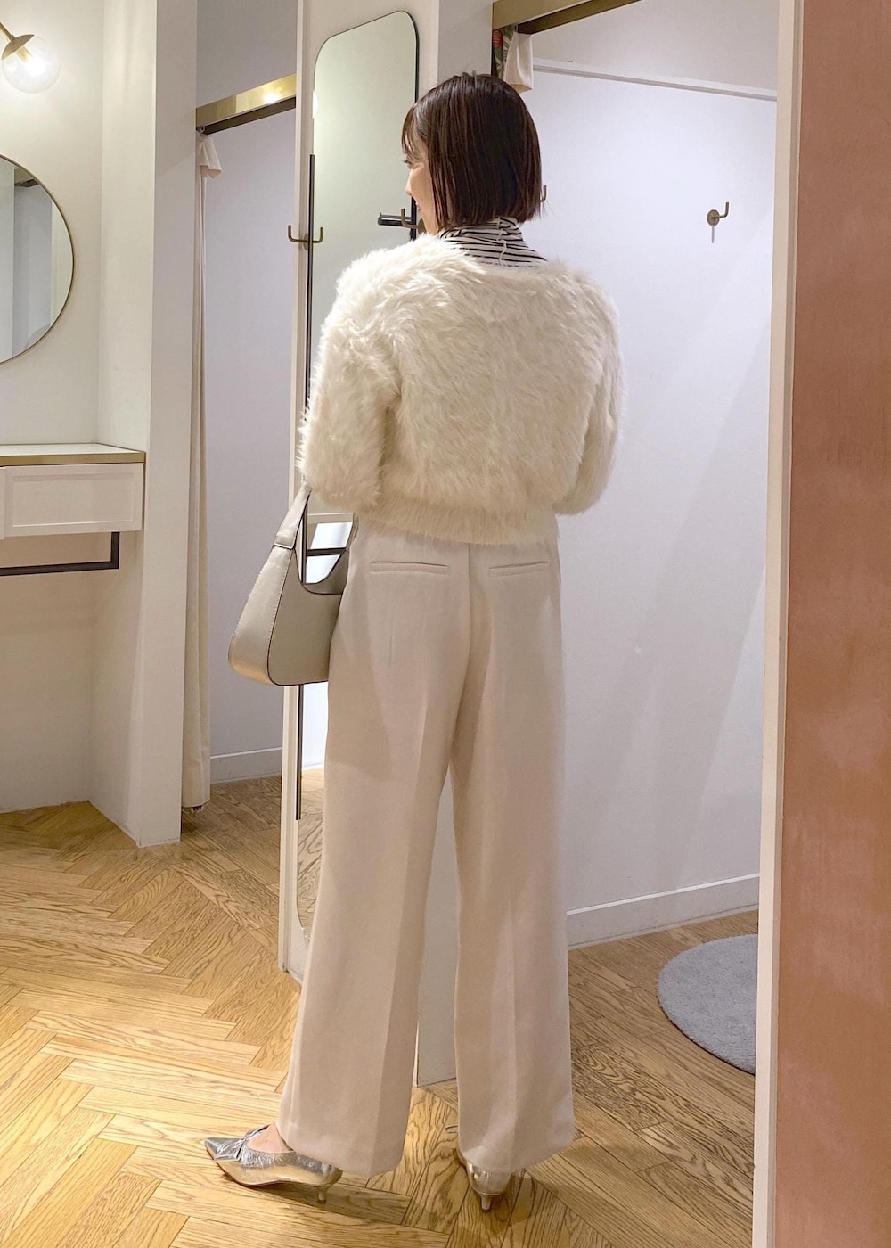 シルバー系のパンプス、ホワイト系のカーディガン/ボレロ、ホワイト系のTシャツ/カットソーを着用したレディースの冬コーディネートの3枚目の写真